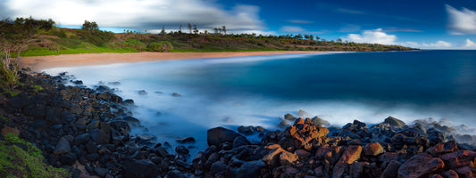 Fine art photograph of Donkey Beach on Kauai, by Inspiring Images Hawaii. This scenic landscape photograph shows the beach in the background with a smooth deep blue ocean in the foreground.