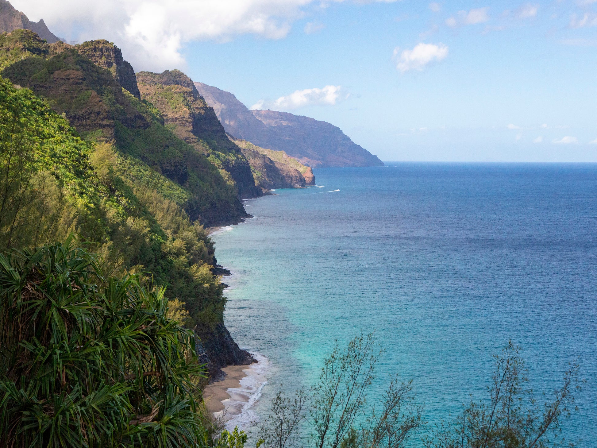 Fine art photograph of Kauai’s Napali coastline taken from the Hanakapi’ai Trail. The lush cliffs drop down to the bright blue ocean. Landscape photo by Inspiring Images Hawaii.