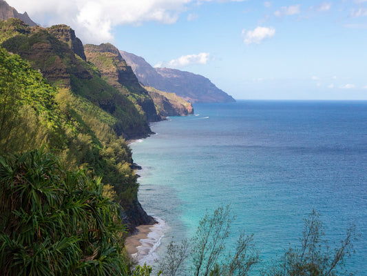 Fine art photograph of Kauai’s Napali coastline taken from the Hanakapi’ai Trail. The lush cliffs drop down to the bright blue ocean. Landscape photo by Inspiring Images Hawaii.