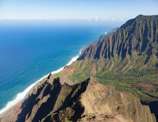 Fine art photograph of Kalalau Valley on Kauai, taken from a trail along the side of the valley with the ocean in the background and one of the razor sharp ridge lines in the foreground. Landscape photography by Inspiring Images Hawaii.