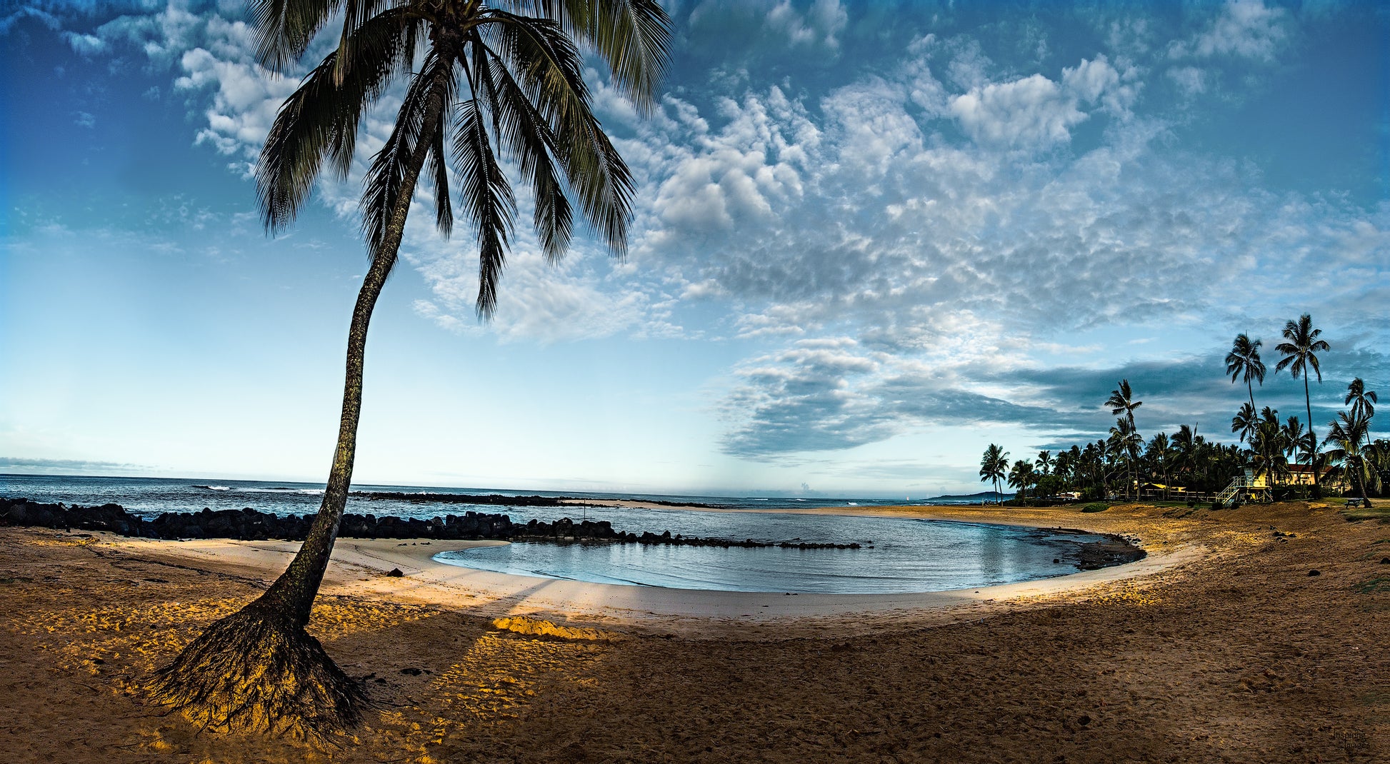 Fine art photograph of Kauai’s popular popular Poipu Beach. The empty early morning beach is shaded by a palm tree in this landscape photograph by Inspiring Images Hawaii.