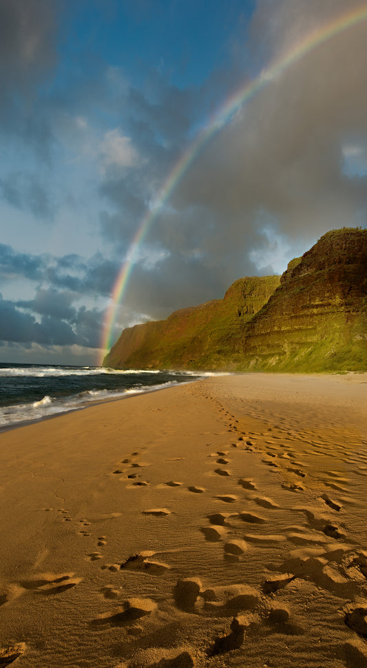 A rainbow arches over the beach and cliffs of Polihale Beach on Kauai. Fine art photograph by outdoor and landscape photographers Inspiring Images Hawaii.